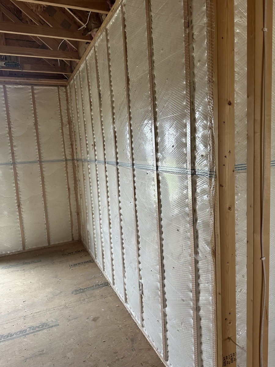 Sidewalls sheeted in plastic before spray foam installation